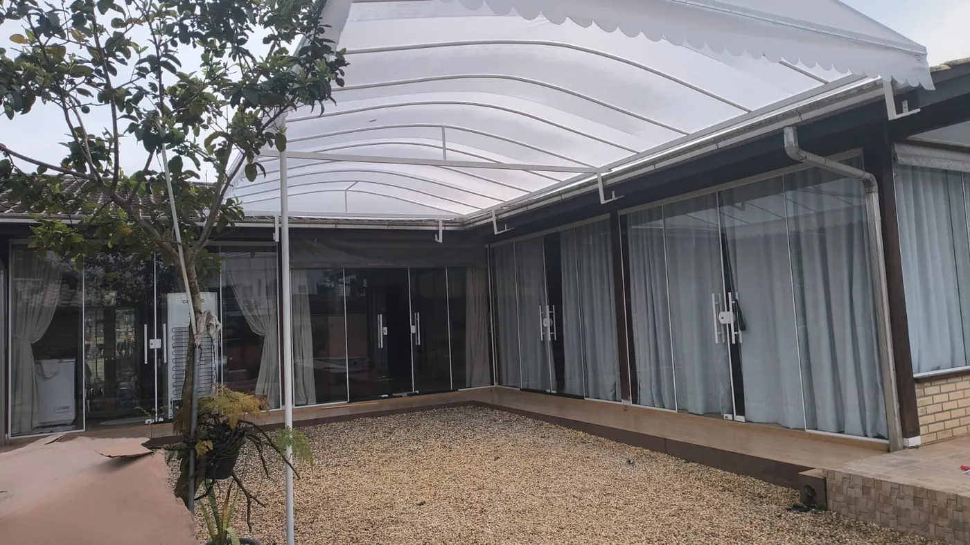 Cobertura curva em área externa, obra da Tecno Toldos e Lonas