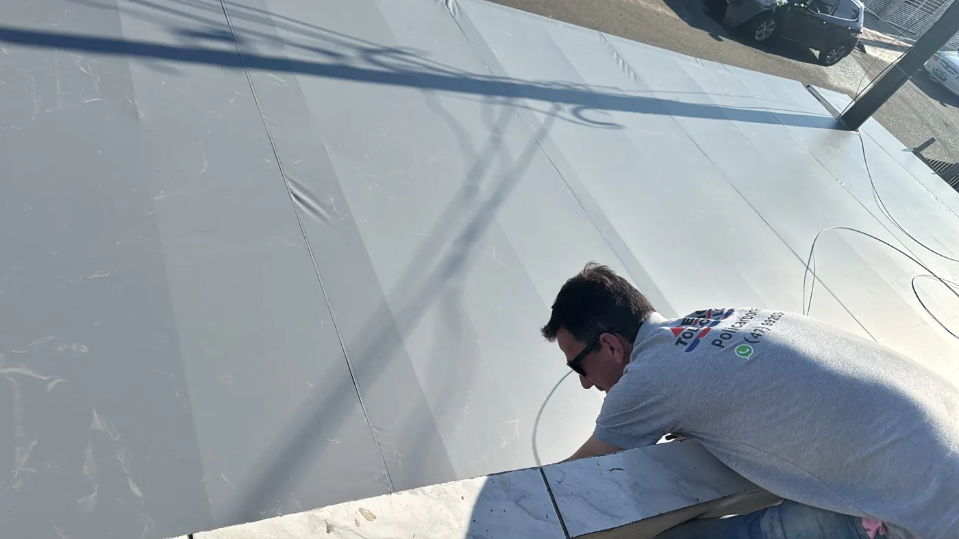 Equipe cortando a lona sob medida, obra da Tecno Toldos e Lonas
