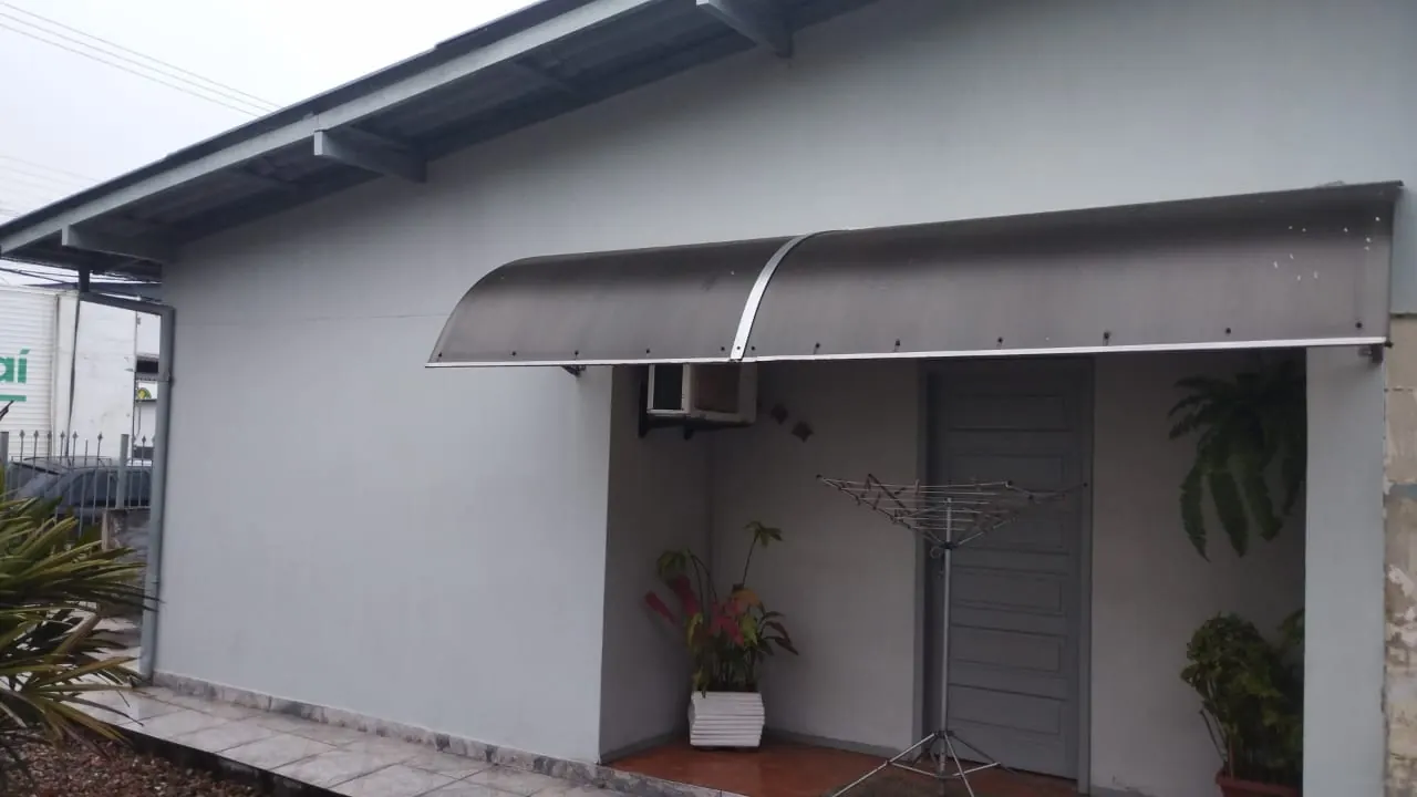 Toldo em arco sobre a entrada de casa, obra da Tecno Toldos e Lonas