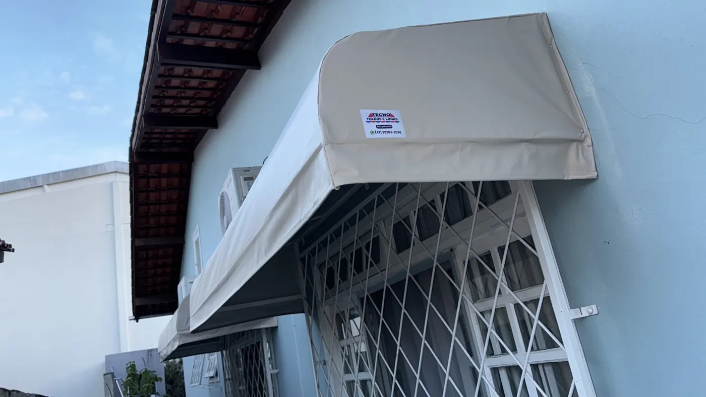 Toldo bege em fachada residencial, obra da Tecno Toldos e Lonas
