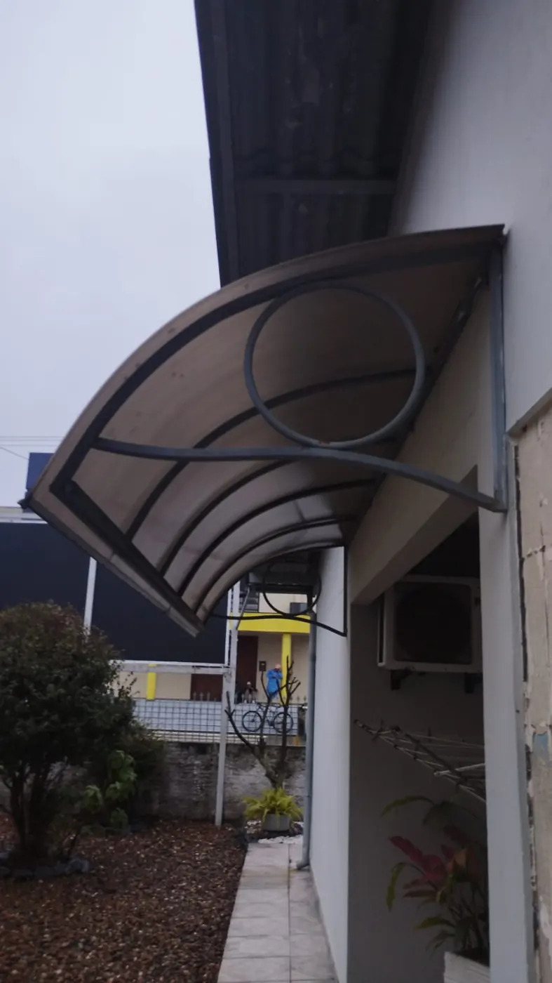 Toldo curvo em entrada de casa, obra da Tecno Toldos e Lonas